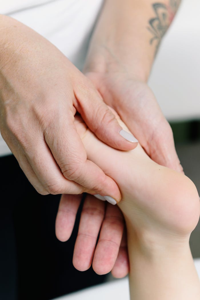 A physiotherapist giving a foot massage in a healthcare setting for relaxation.