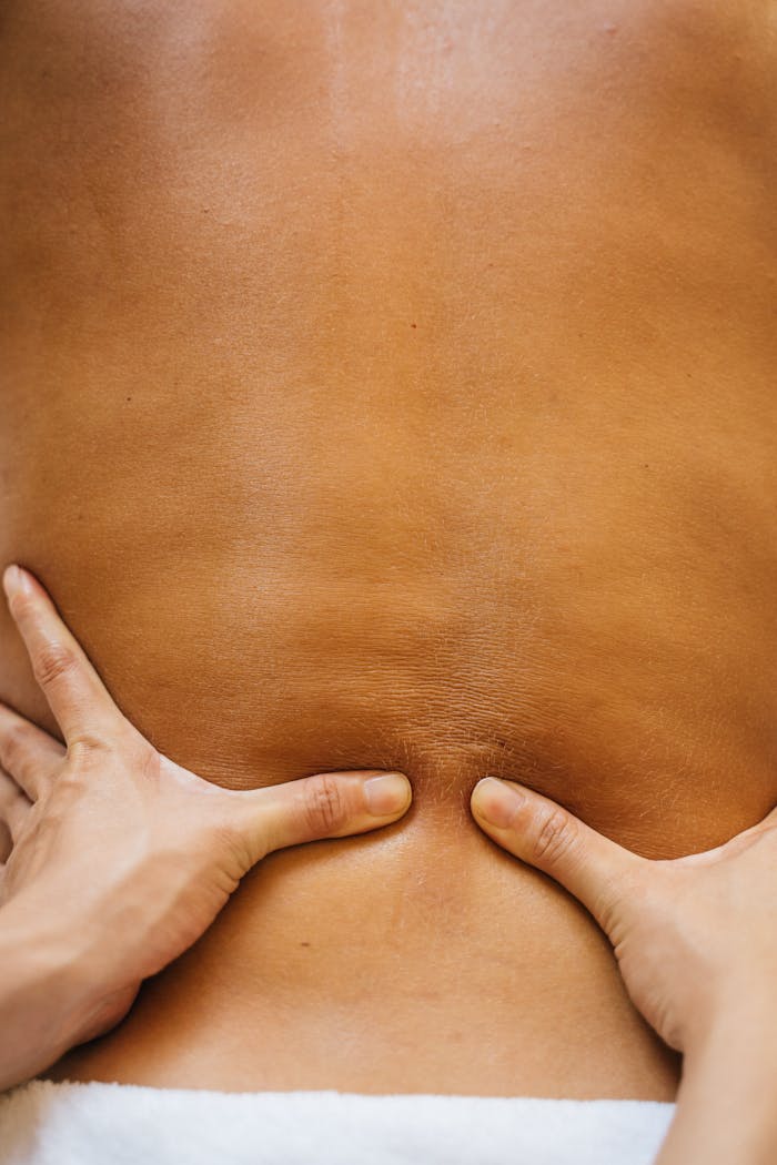 Close-up of hands performing a relaxing massage on a client's back, focusing on wellness and relaxation.